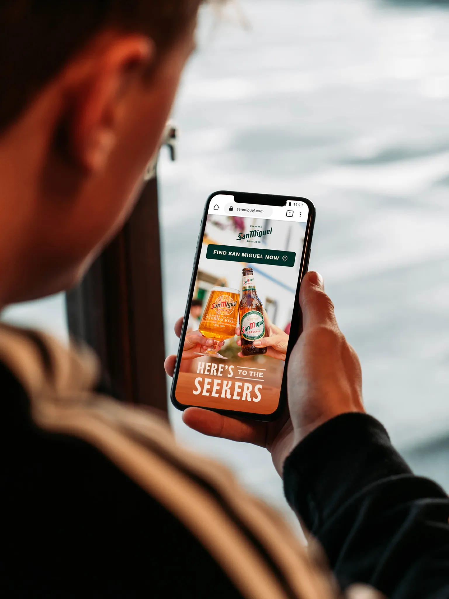 Person viewing San Miguel beer ad on mobile phone.